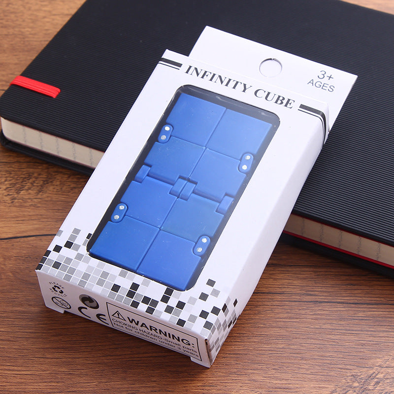 Infinity Cube in its retail box — blue fidget cube on a desk