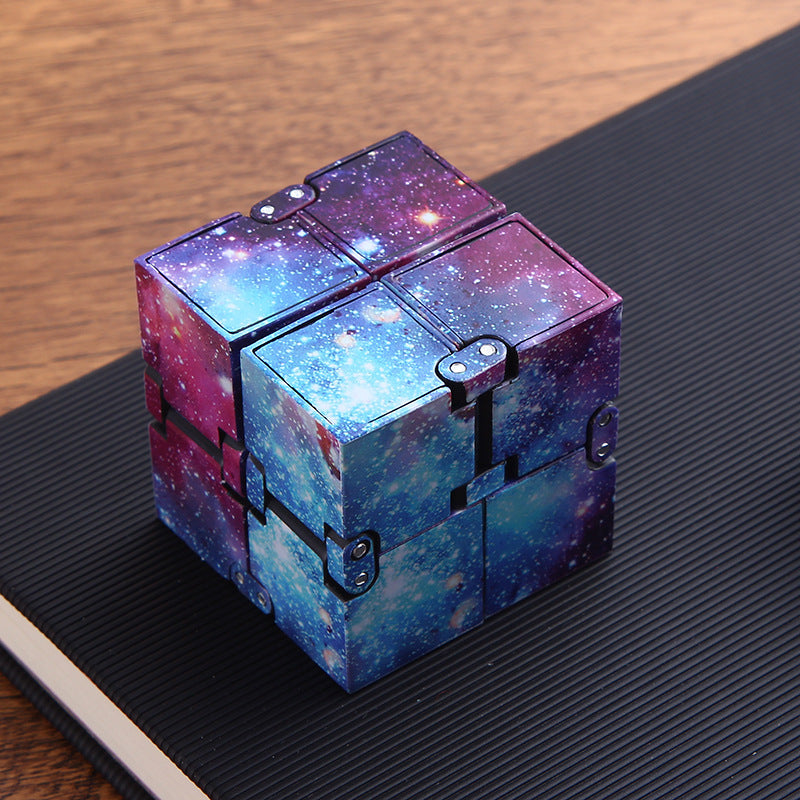 Infinity Cube — Starry Sky fidget cube resting on a desk mat