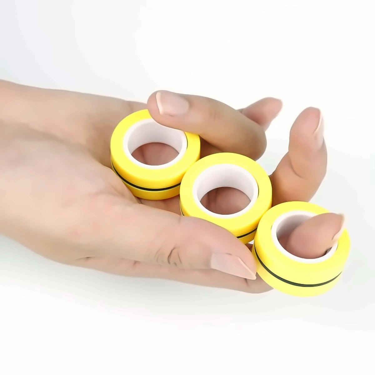 Magnetic Rings on fingers — yellow magnetic fidget rings held in hand
