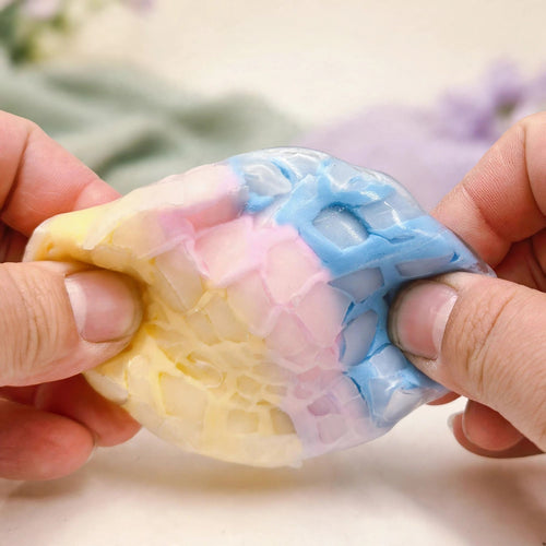 Crunchy Squeeze Ball — pastel mosaic crunchy squeeze ball being squeezed by two hands