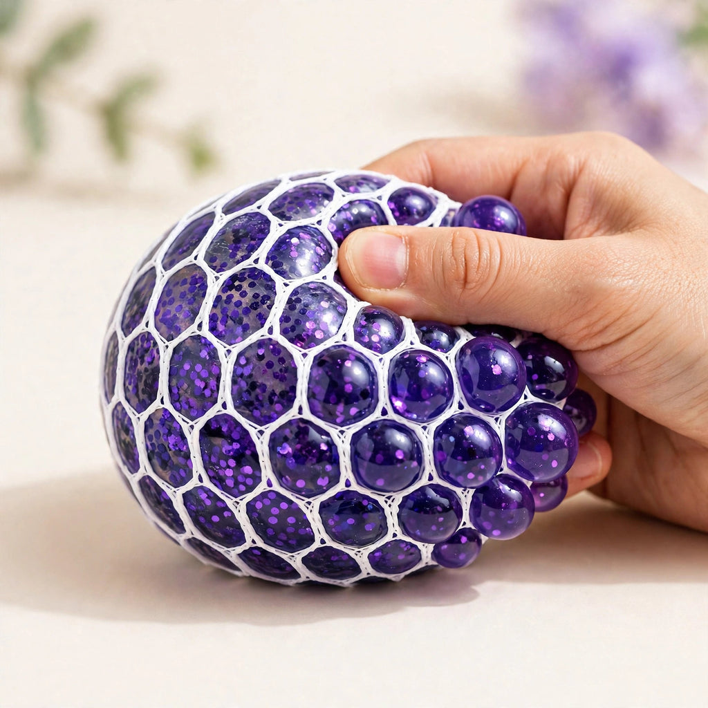 Grape Pop Ball — purple mesh squeeze ball with gel beads bulging through the net as a hand squeezes it