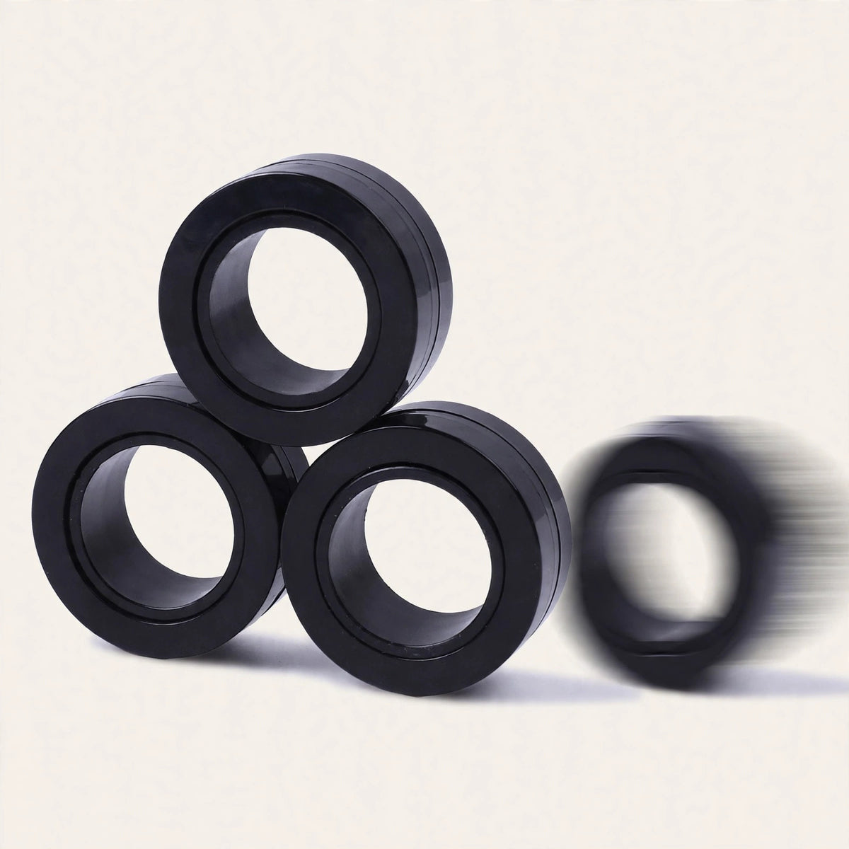 Magnetic Rings — black magnetic fidget rings stacked on a cream background