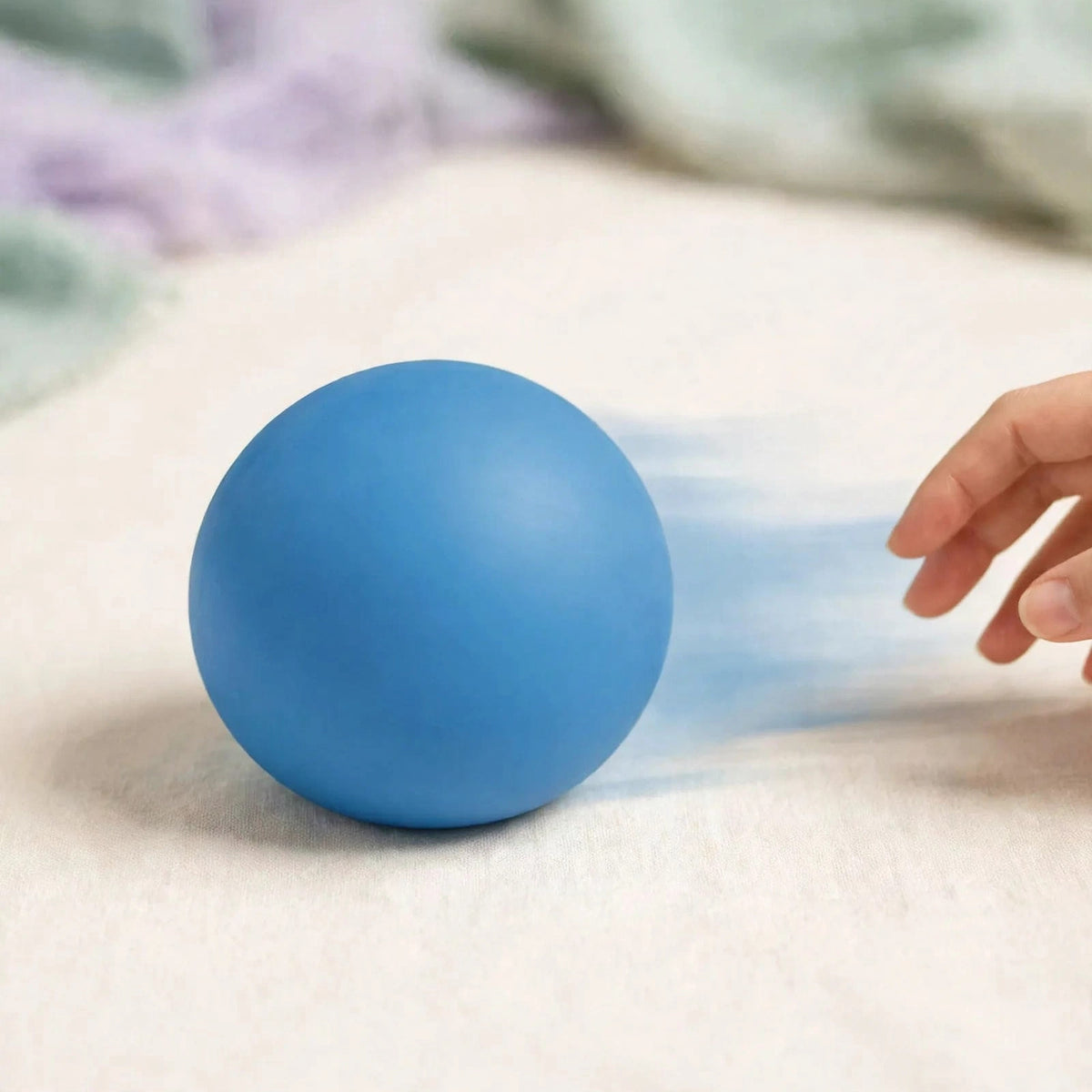 Malt Sugar Dough Ball — smooth blue malt sugar squeeze ball mid-roll on a cream surface